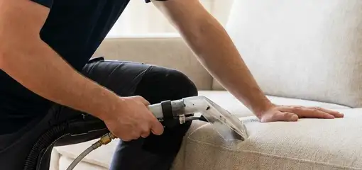 Professional upholstery cleaner deep-cleaning a fabric sofa with a handheld extraction tool, Chattanooga, TN.